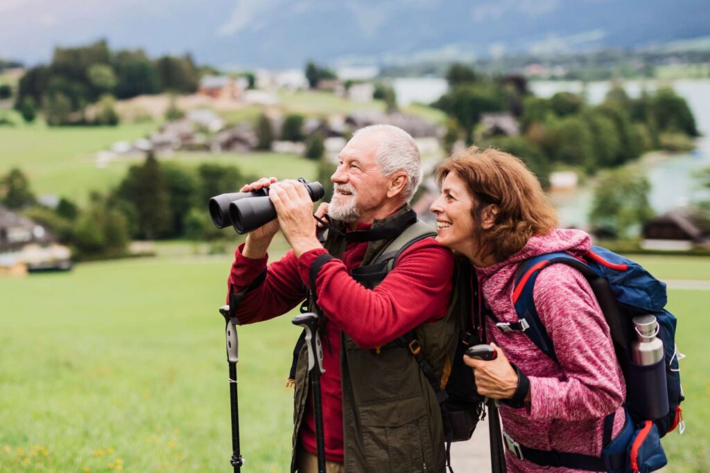 Ein Paar beobachtet die Natur mit Hilfe eines Fernglases beim Wandern