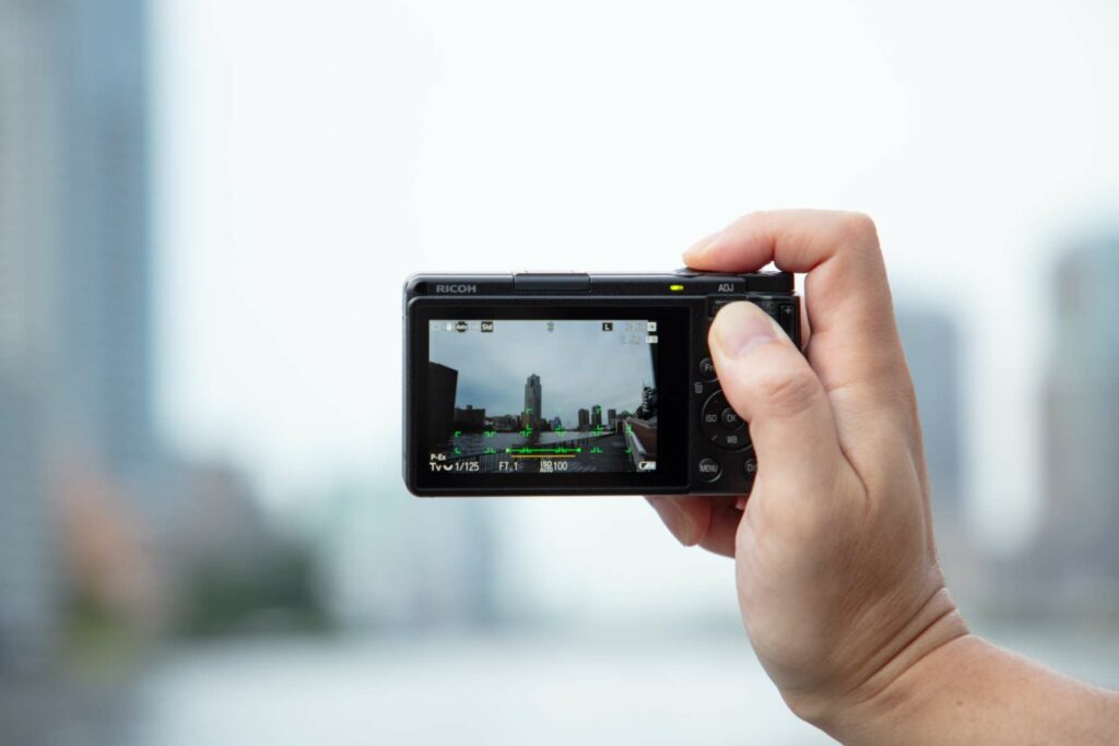 Ricoh GR IV in der Hand gehalten beim Fotografieren