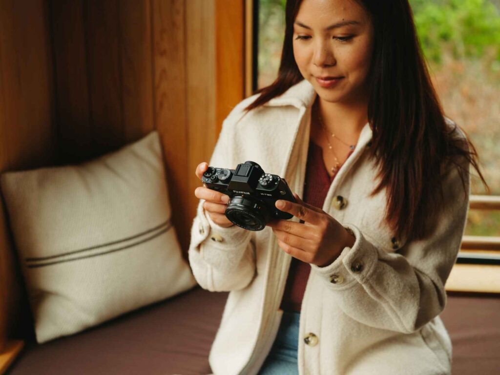 Fotografin schaut sich die Ergebnisse einer Fotosession auf dem Touchscreen der X-T30 iii an