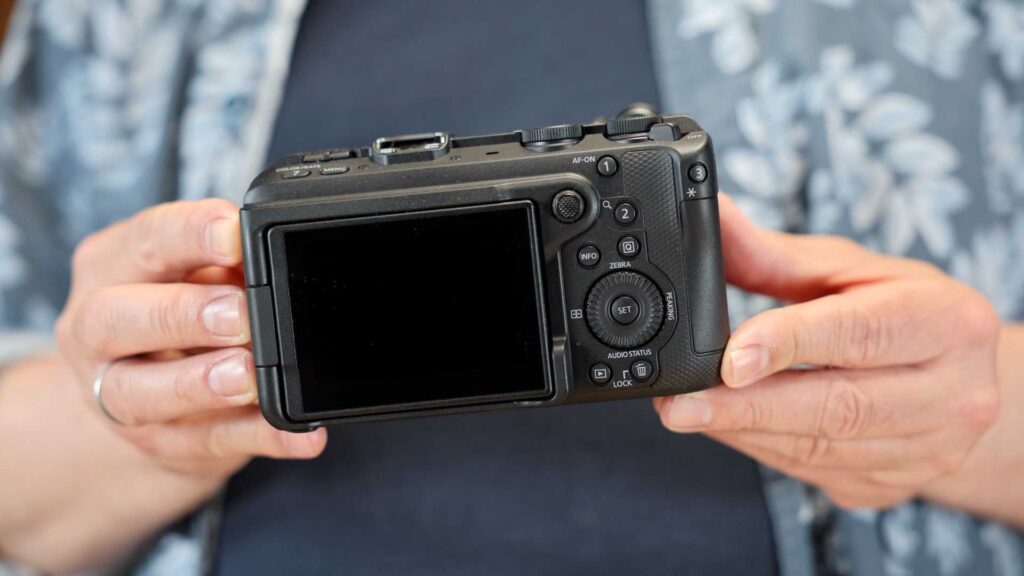 Canon EOS R6 V in den Händen gehalten. Rückseite mit Bedienelementen und Display.